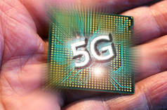 男人手中的微处理器上的5G字。现代电路、高速移动互联网和下一代网络技术中5G网络通信的概念.