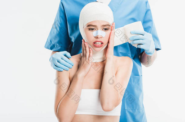  外科医生在手套录音妇女脸与绷带后, 整形手术隔离在白色