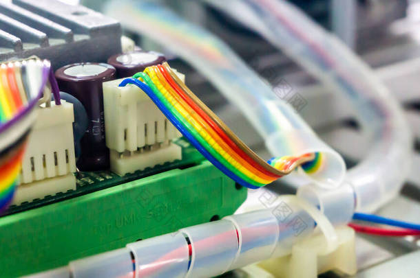 工业电机上连接到终端<strong>块</strong>连接器的扁平彩虹丝带电缆的近景。选择角度和焦点。工业工作概念.