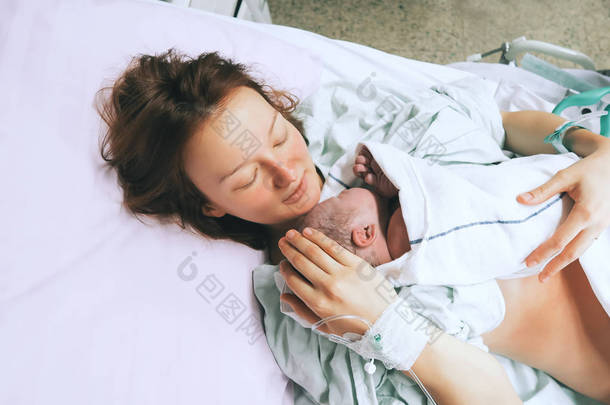 妈妈抱着她刚出生的<strong>婴儿</strong>在医院分娩后. 
