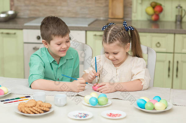 儿童男孩和女孩玩复活节彩蛋和笑