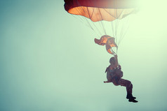 跳伞运动员在彩色降落伞在阳光明媚的晴空.