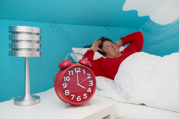 高级女人躺在床上生病和遭受失眠或 insomni
