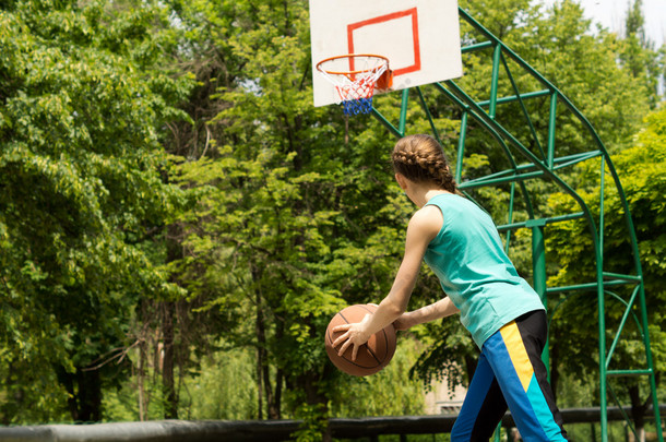 运动型纤细的少年打篮球