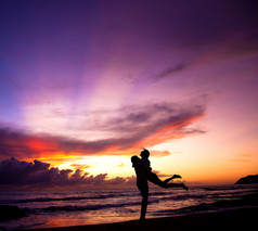 幸福的情侣在沙滩上拥抱的剪影