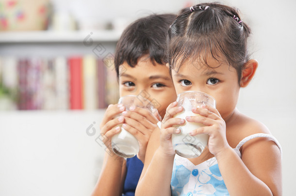 两个小男孩和女孩喝牛奶