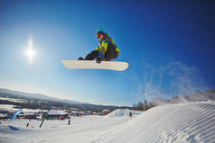 飞越雪堆的滑雪运动的人 