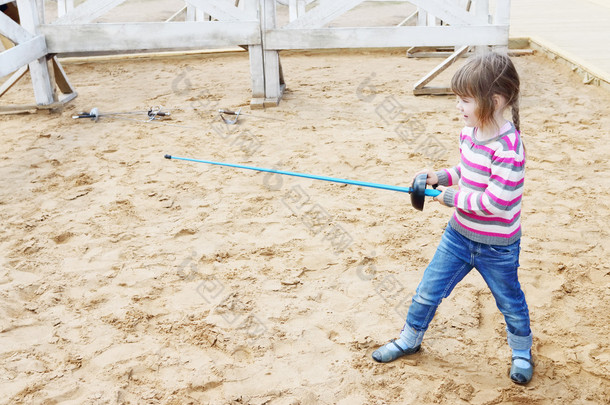 漂亮的小快乐的女孩，站在蓝色的<strong>剑</strong>杆织机火车沙上