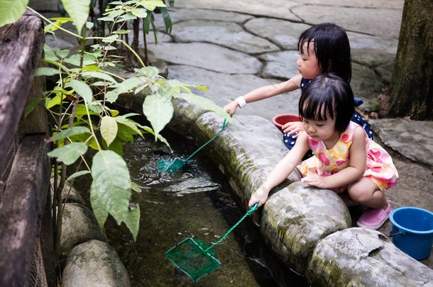 亚洲的中国小女孩用勺钓<strong>鱼</strong>网在<strong>池塘</strong>