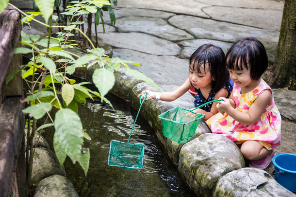 亚洲的中国小女孩用勺钓鱼网在<strong>池塘</strong>