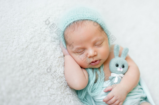 可爱熟睡的婴儿，与蓝色的帽子、 内裤和玩具