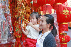 中国农历新年春节在唐人街在曼谷，泰国亚洲女人和她的女儿在中国服饰对传统中国红装饰是很受欢迎.