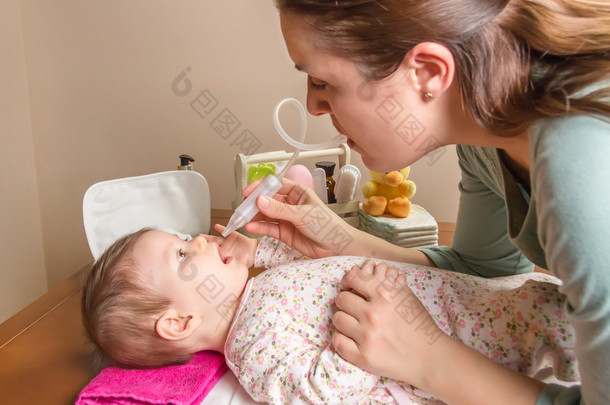 妈妈在打扫粘液婴儿吸鼻器