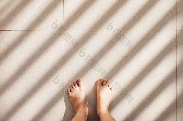 赤脚的人站在人行道地板 
