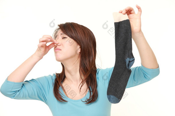 日本女人抱着她的鼻子因为袜子难闻的气味