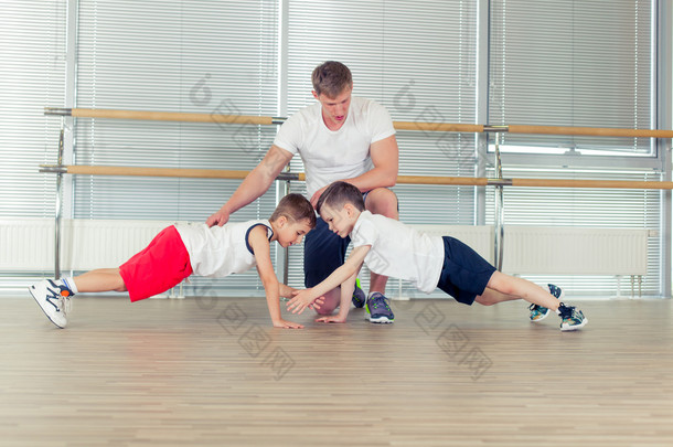 组的孩子在做幼儿园老师与孩子在体育馆里的体操