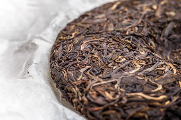 老沈中国发酵的普洱茶在纸莎草纸纸张背景微距特写 