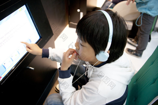 小男孩看着监视器在首尔国际车展