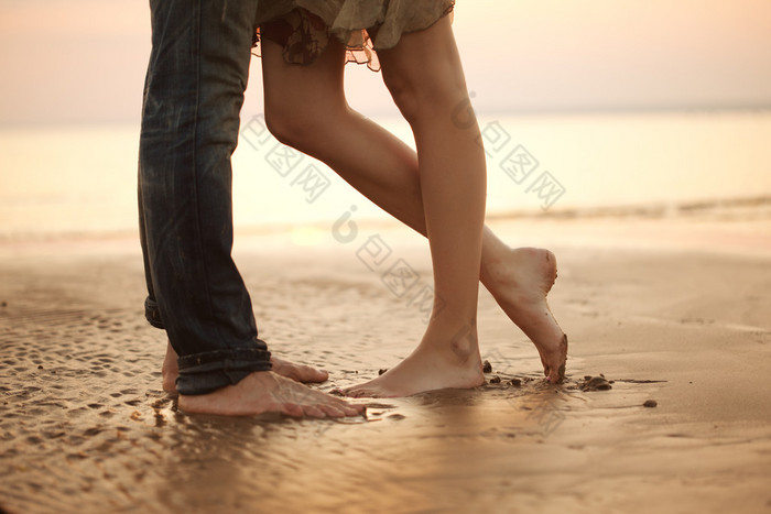 拥抱和亲吻在沙滩上恩爱的小夫妻恋人