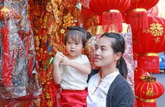 中国农历新年春节在唐人街在曼谷，泰国亚洲女人和她的女儿在中国服饰对传统中国红装饰是很受欢迎.