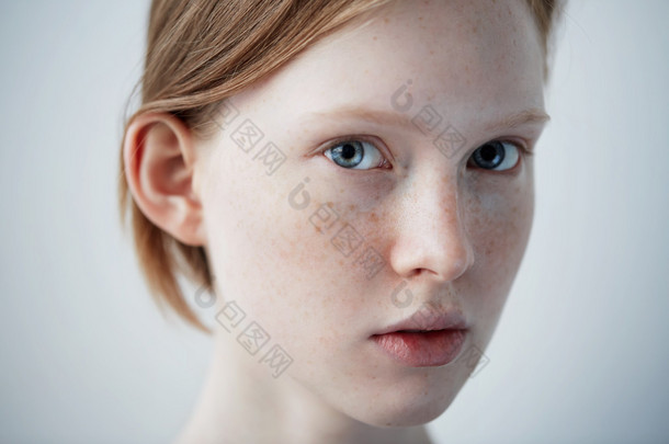 美丽的女孩脸画像漂亮的模特的女人雀斑完美新鲜干净的皮肤红发女看着照相机青年和皮肤护理概念孤立对背景.