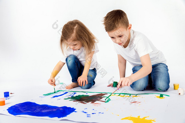 两个漂亮的孩子朋友男孩和女孩正在画画的<strong>涂料</strong>