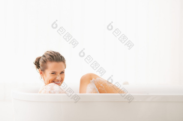 快乐的年轻女人在浴缸里洗澡