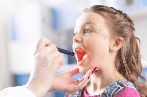 医生检查喉咙里的女孩