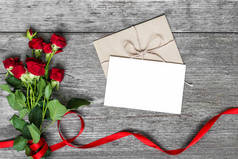 空白的白色贺卡和信封用红玫瑰鲜花
