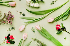 花卉图案由粉红色的郁金香, 玫瑰, 金丝桃花在绿色的背景。平躺, 上观春花理念.
