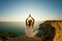 美丽适合在日出或日落山顶瑜伽锻炼瑜伽的女孩.