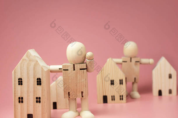 木娃娃站在房子旁边.鼓励采取各种措施待在家里。待在家里的概念.