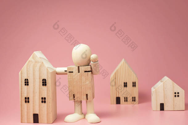 木娃娃站在房子旁边。鼓励采取各种措施待在家里。呆在家里.
