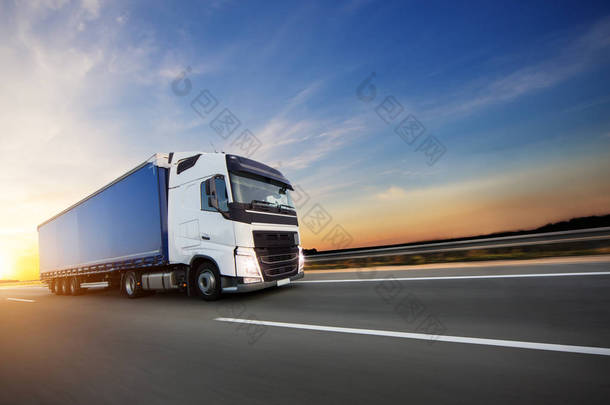 装载欧洲卡车在机动车路在美丽的日落光。论道路运输与货运.