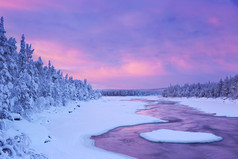 在一个冬天的风景，芬兰拉普兰的湍急河流上空的日出