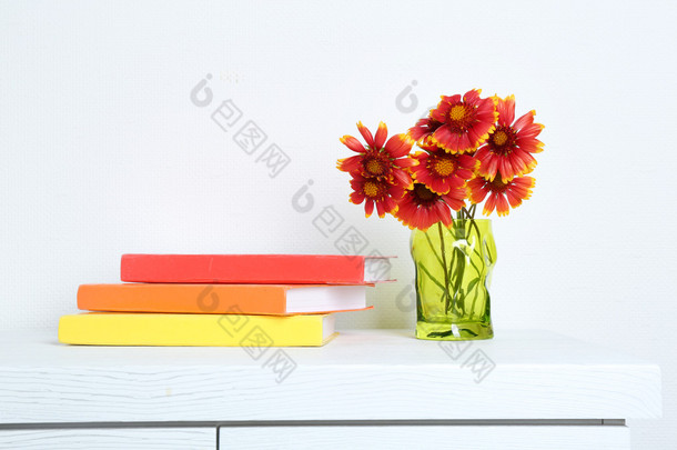 美丽的鲜花，插在花瓶里用的背景墙上的书