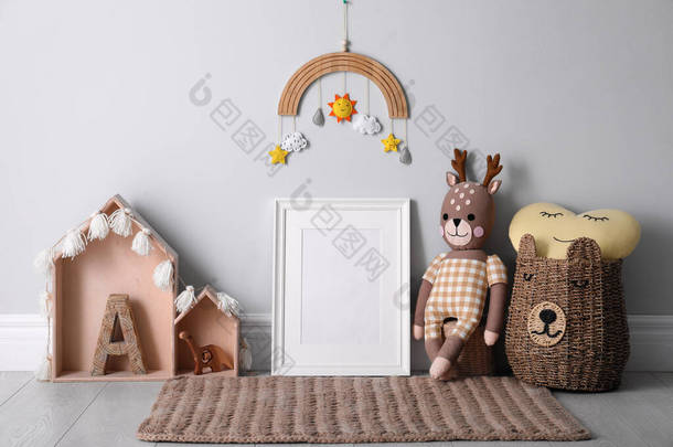 婴儿房墙边的空相框和可爱的玩具。室内设计