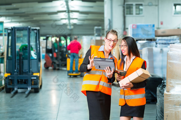 workers with package in warehouse of forwarding