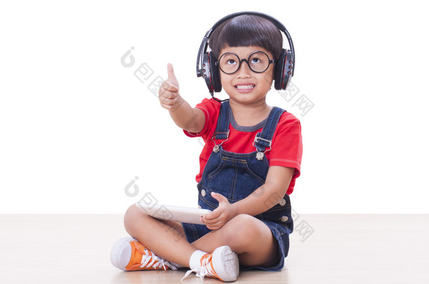快乐的男孩，戴着耳机连接到一台平板电脑