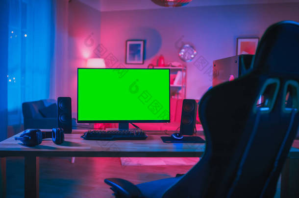 强大的个人电脑玩家Rig与模拟绿屏显示器站在桌子上在家里。舒适的房间与<strong>现代设计</strong>是点亮与粉红色的霓虹灯.