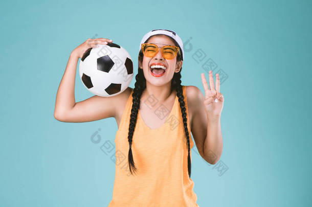球迷体育妇女微笑和快乐, 举行一个足球, 庆祝点三手指上第三个标志