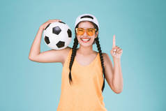 球迷体育妇女微笑和快乐, 拿着一个足球, 庆祝点一手指向上优胜者标志