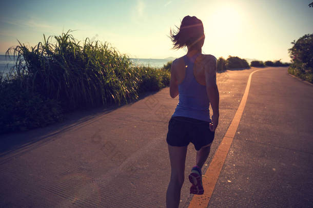 健康的女人早上在海滨小径上奔跑