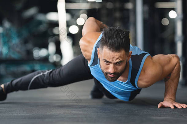 肌肉男子做俯卧撑手在健身房