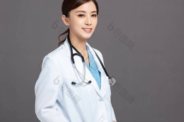 身穿白衣的亚裔女医生微笑