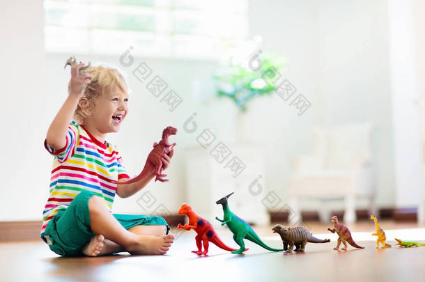 玩玩具恐龙的孩子。儿童玩具.
