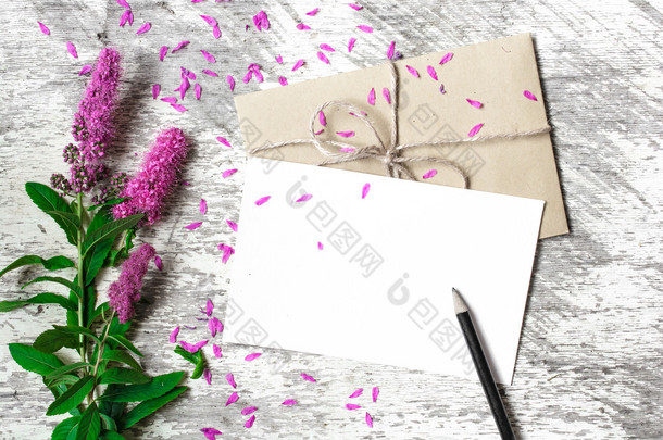 空白的白色贺卡、 信封和紫色的野花的铅笔
