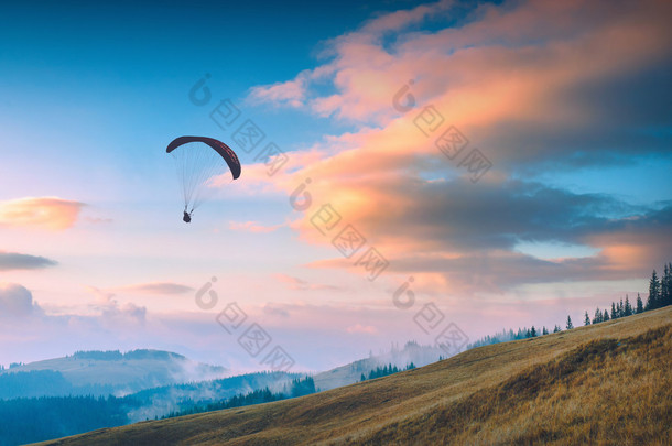 可以通过滑翔伞在喀尔巴阡的夕阳的天空