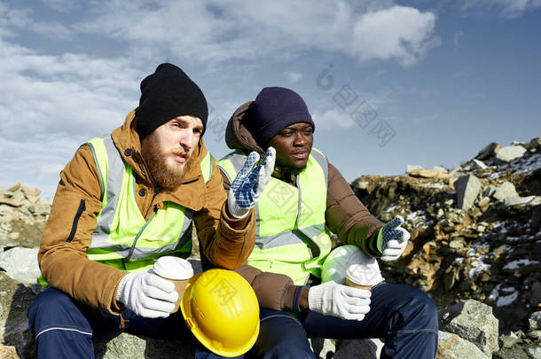 两名工业<strong>工人</strong>的肖像穿着反光夹克, 其中一个非洲人, 放松从工作中抽出咖啡休息和聊天在露天采矿工地