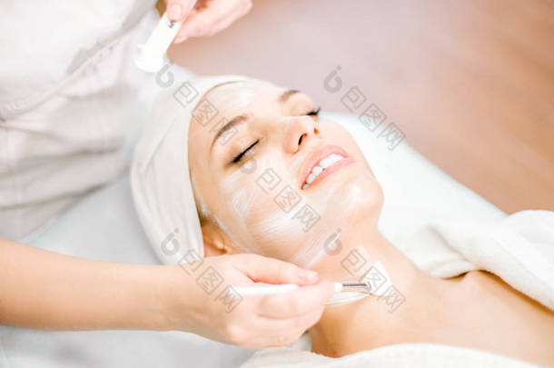 美容。美容师的手<strong>使用</strong>刷子进行清洁面膜。面部恢复手术